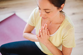 Janine Rietdorf meditiert auf einer Yogamatte im Studio